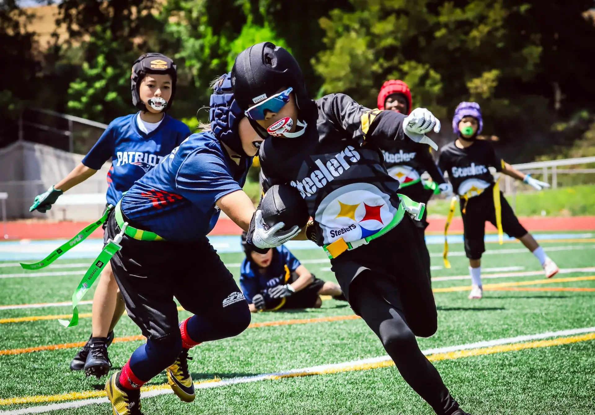 CFA Steelers player running past a flag defender