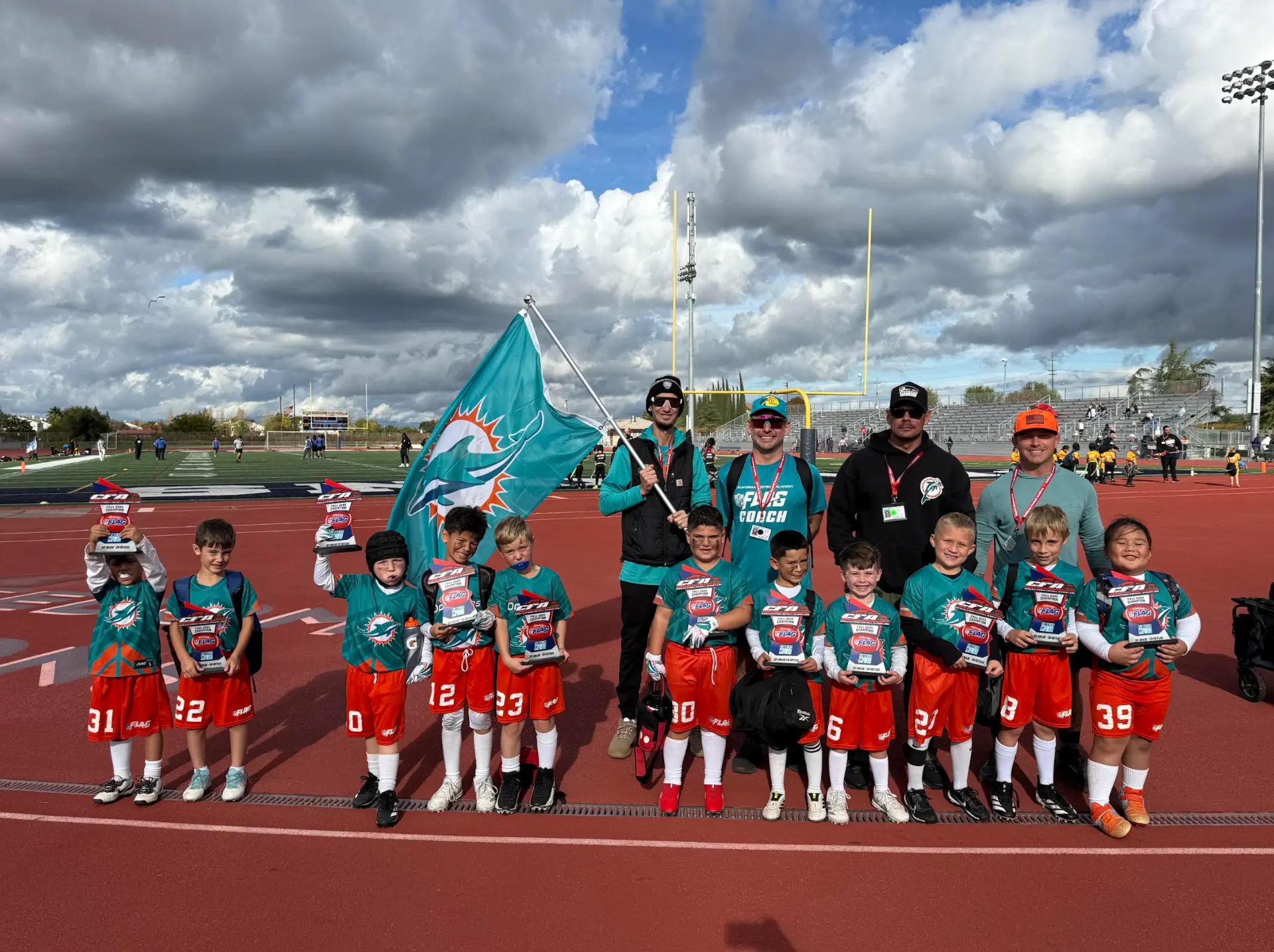 CFA youth team and coaches on the track