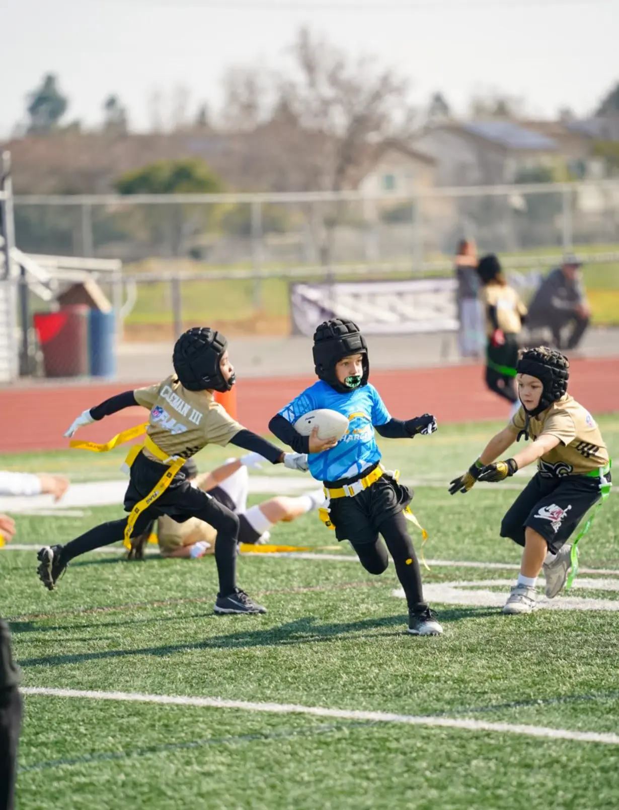 CFA youth player in blue running with the football